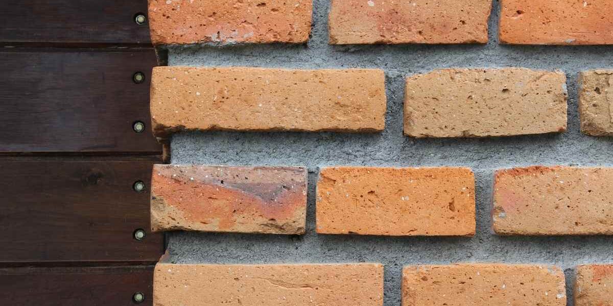 Mur en briques rouges avec planches sombres et vis métalliques
